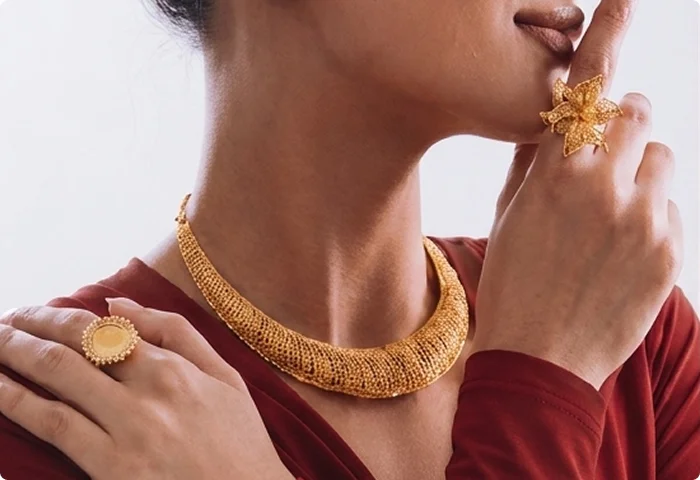 Model wearing gold necklace and ring